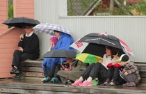 Pelin alussa satoi ja peliä seurattiin sateenvarjojen alta